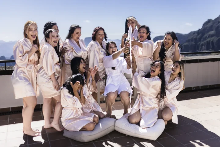 Grupo de mujeres celebrando en bata blanca con vistas montañosas