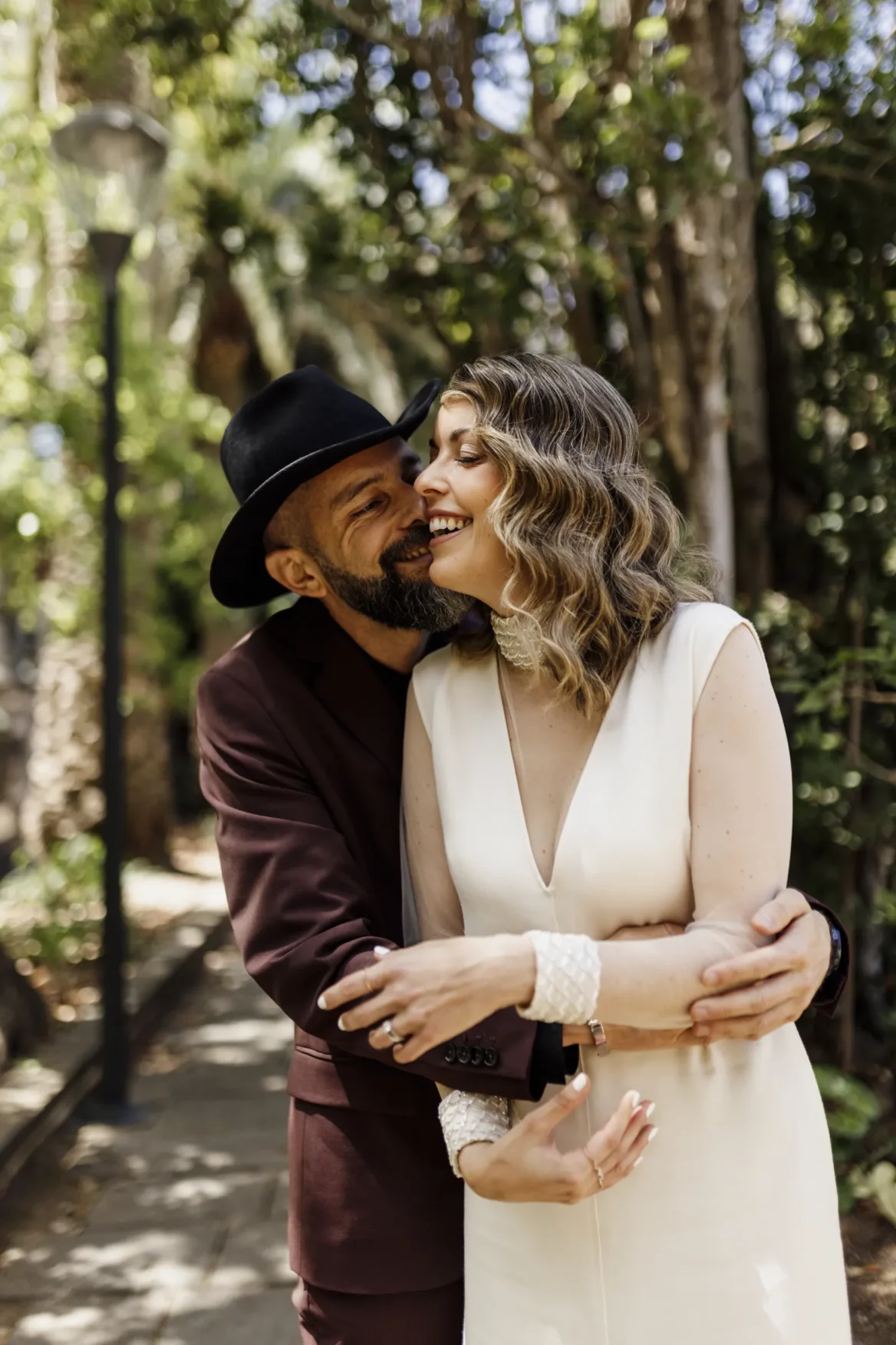Pareja feliz besándose en jardín arbolado y romántico