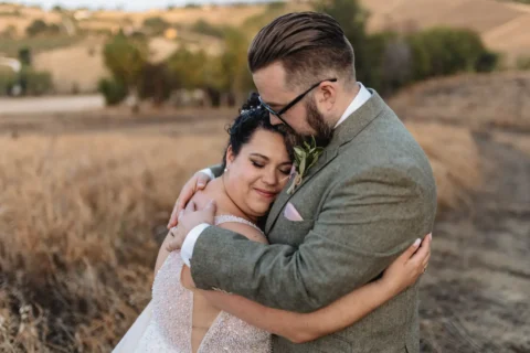 Pareja recién casada abrazándose en campo rural